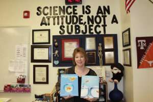 Mrs. Minter poses with her textbook titled "Psychology". It was published by Prentice Hall. Photo by F. Song. 