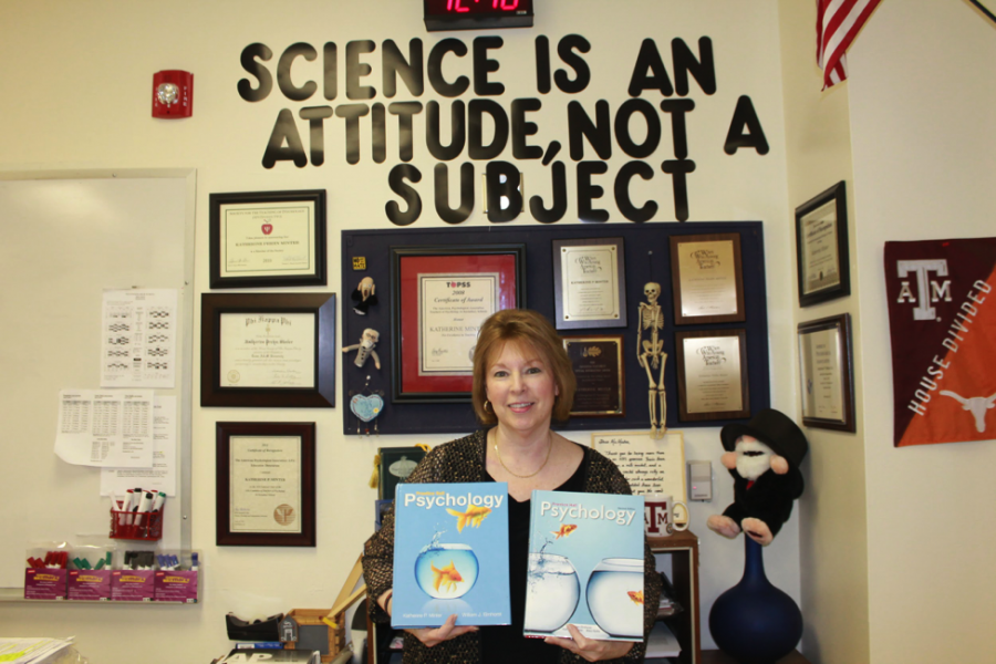 Mrs. Minter poses with her textbook titled Psychology. It was published by Prentice Hall. Photo by F. Song. 