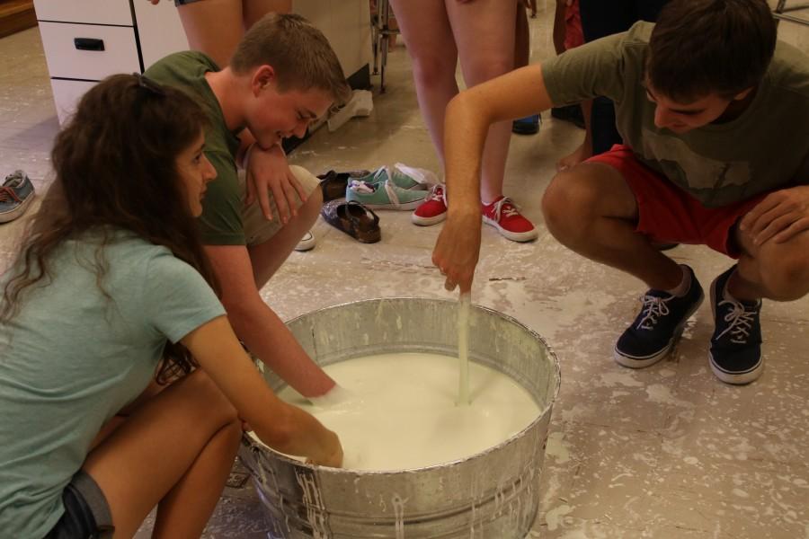 Kremena Mavrodieva 16 and Spencer Rhea 16 put their hands in the non-newtonian fluid.