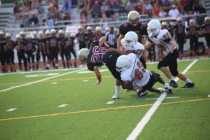 The Warriors tackle a rushing Rouse player to the ground.