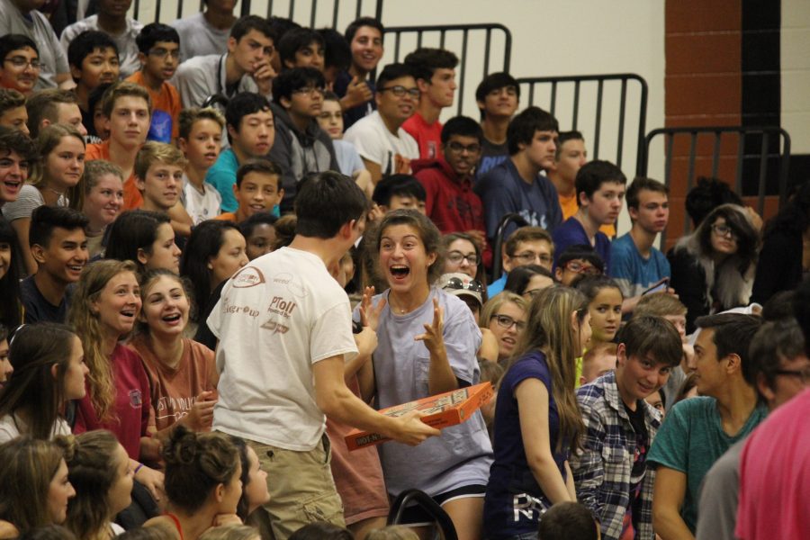 Stephanie Jbeily 19 and Jack Pitre 19 celebrates with friends after bring given a pizza at the pep rally.