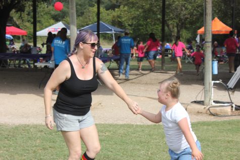 A woman and girl with Down syndrome dance to the music after the walk.