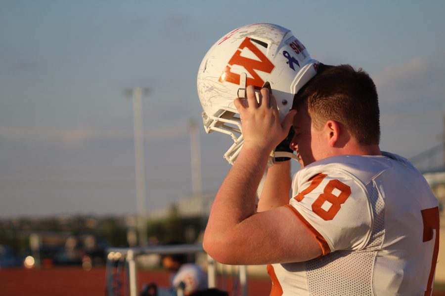Tristan Smith 18 puts his helmet on after the national anthem. 
