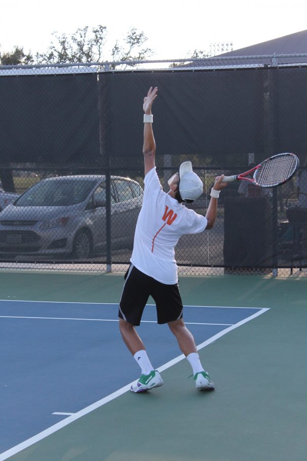 Truman Le 19 leans back to follow the ball for his serve. 