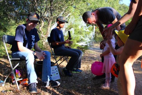 Patrick Devine '20 and Jeffrey Liu '20 pass out candies to trick or treaters on the Haunted Trail.