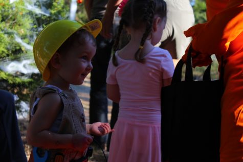A young child watches as candy is passed out to others on the Haunted Trail.
