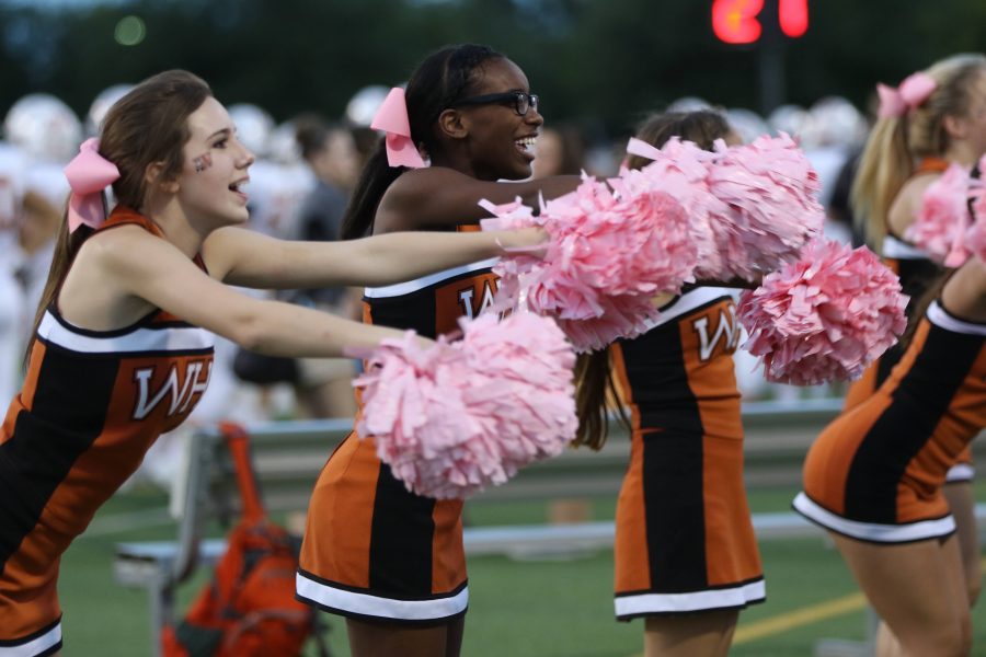 The cheerleaders celebrate the Warriors first touchdown within one minute of beginning the game.