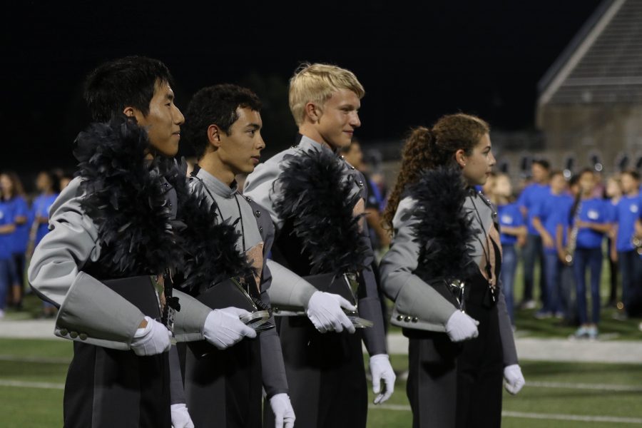 Drum majors James Yan 18 and seniors Jack Scelsi , Cameron Adams, and Maggie Lupo standing at attention. 