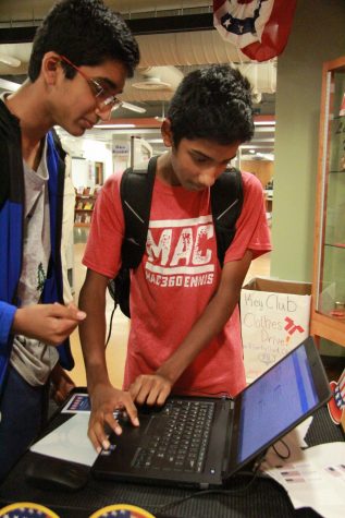 Two friends look up information about the four candidates before casting in their vote.