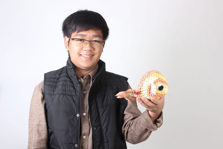 Michael Le 17 shows off his 3D origami fish sculpture. 