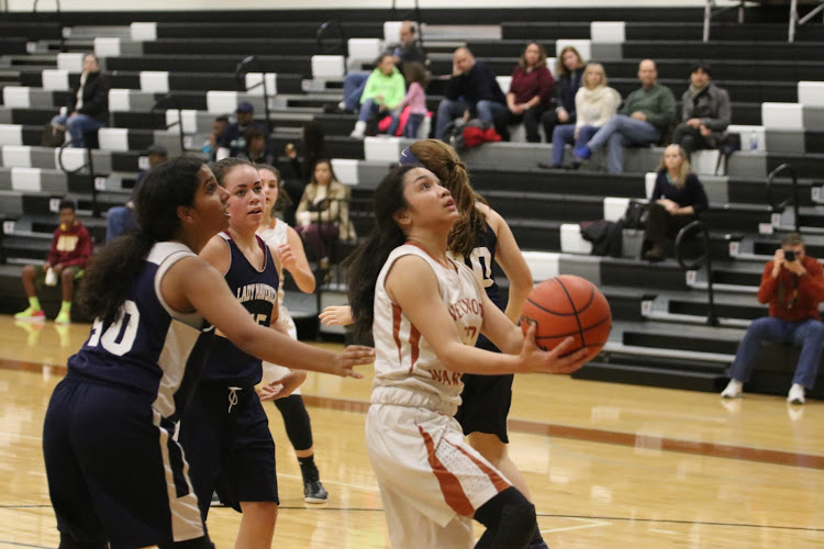 Annalise Galiguez 20 drives to the basket past her opponents.