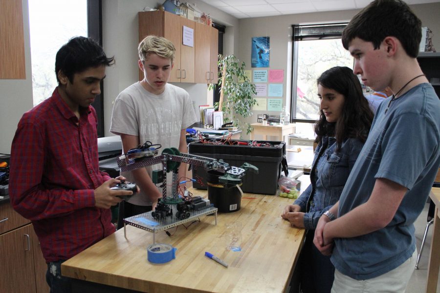 Sophmores John Barlow, Jay Domalapalli, Jack Granger and Vasti Rios make final adjustments on their Surgical Robot Arm before thier final presentation to the class. 
