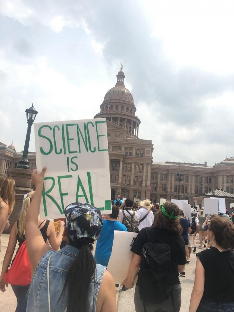 Protesters hold up signs saying Science Is Real.