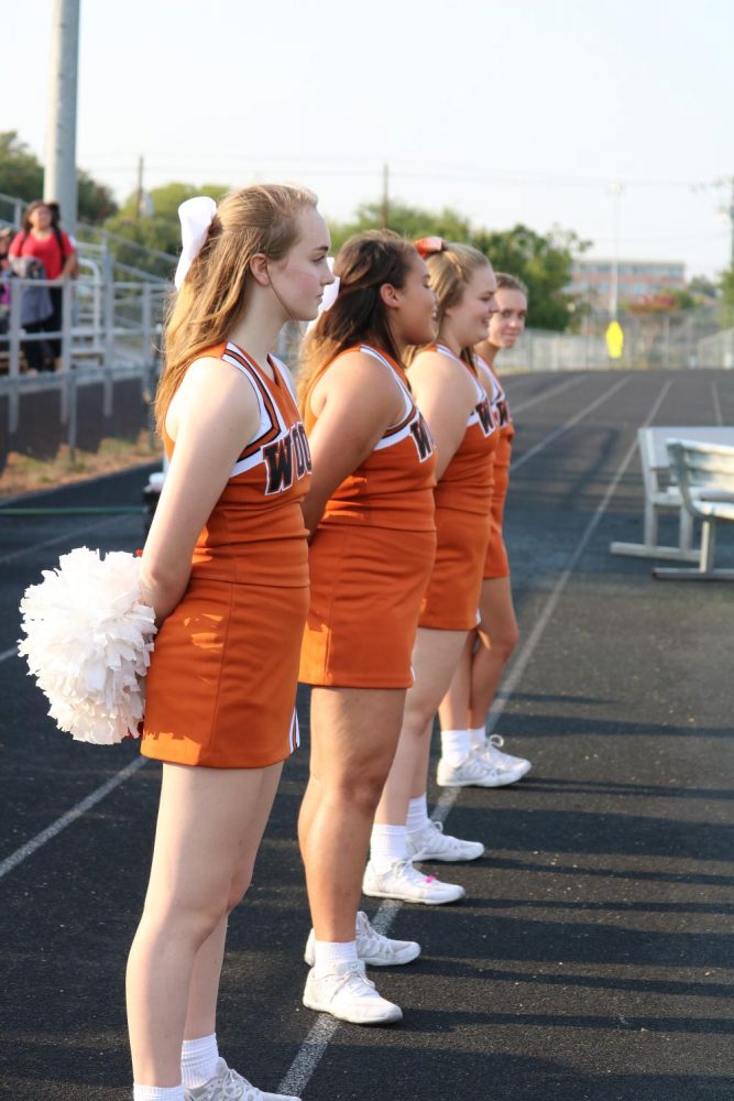 JV cheer stands to watch the team return the ball.