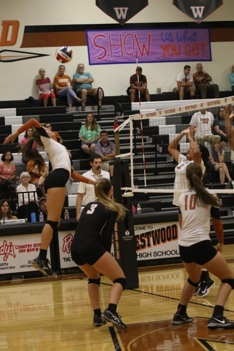 Maddi Kriz 19 springs upwards to spike the ball.