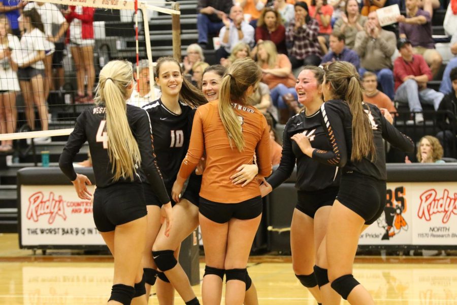 Westwood Lady Warriors come together to celebrate a point earned against Anderson.
