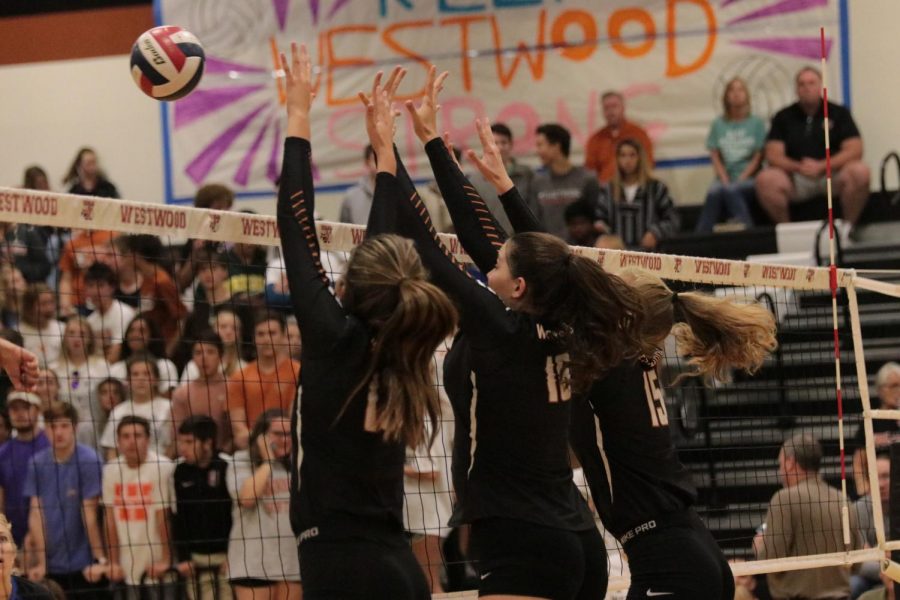 Maddi Kriz 19, Emily Low 18, and Cassie Jackson 18, jump together to block the other teams hit. 