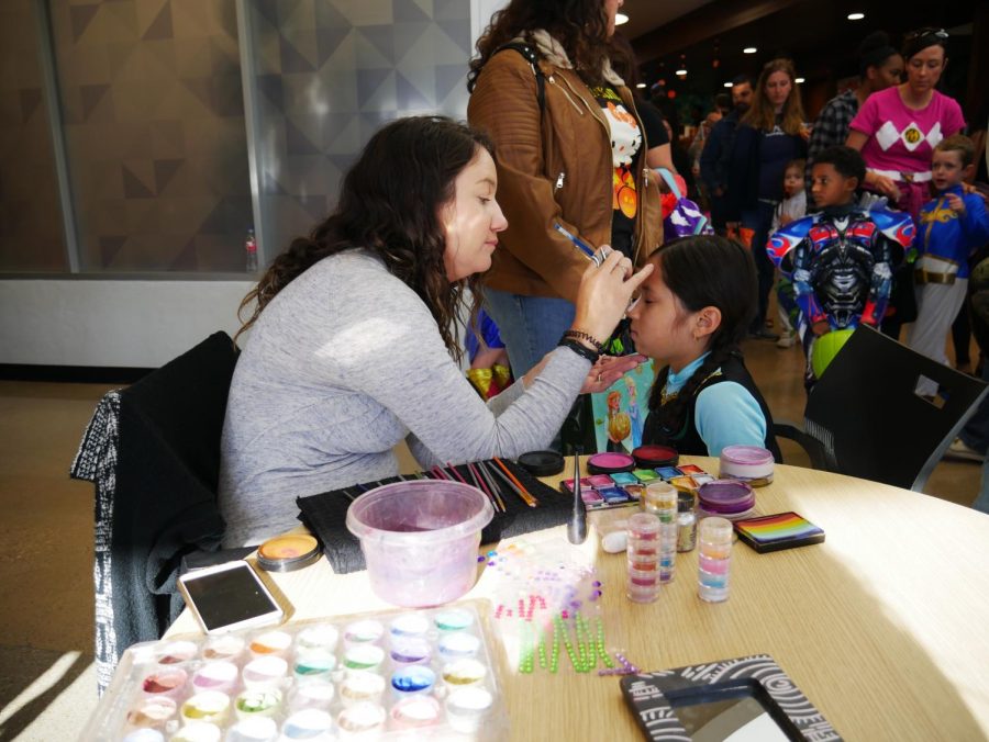 An AVID member concentrates on face painting a bunny.