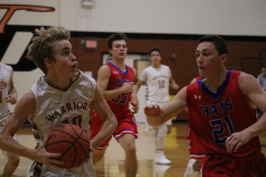 Dylan Granger 19 attempts to make a basket while being guarded by several Hays Rebels. 