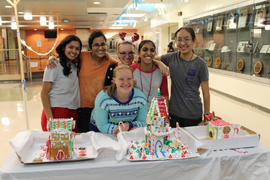 The winning group take a picture with their gingerbread house.