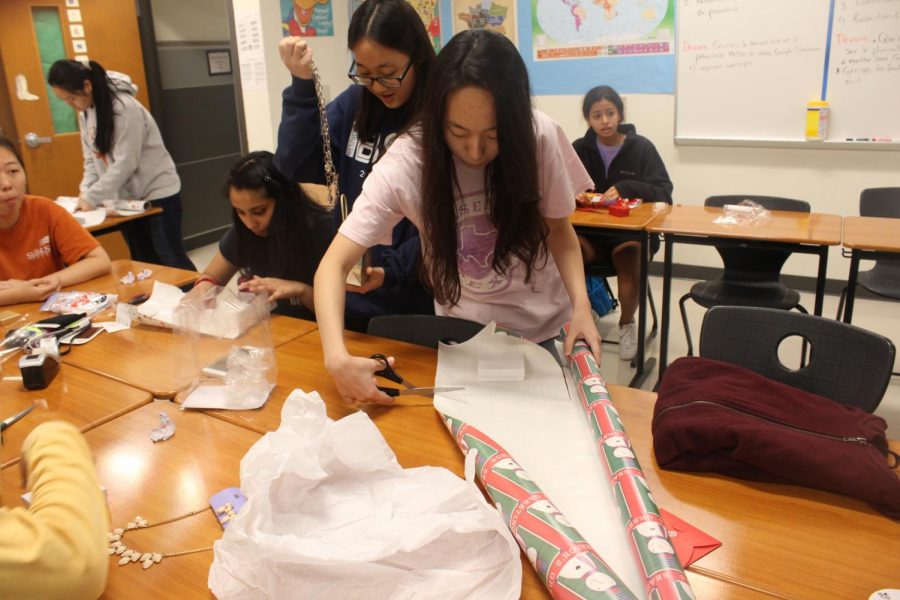 Suji Ro 19 cuts out paper to wrap presents with. 
