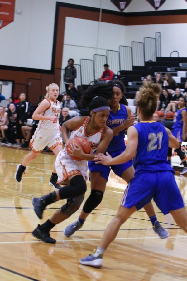Allyah Beaty 18 pushes past two defenders to take a shot.