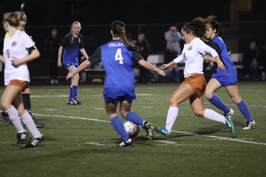 Leah Martinez 19 pushes past two defenders and passes the ball to goal.