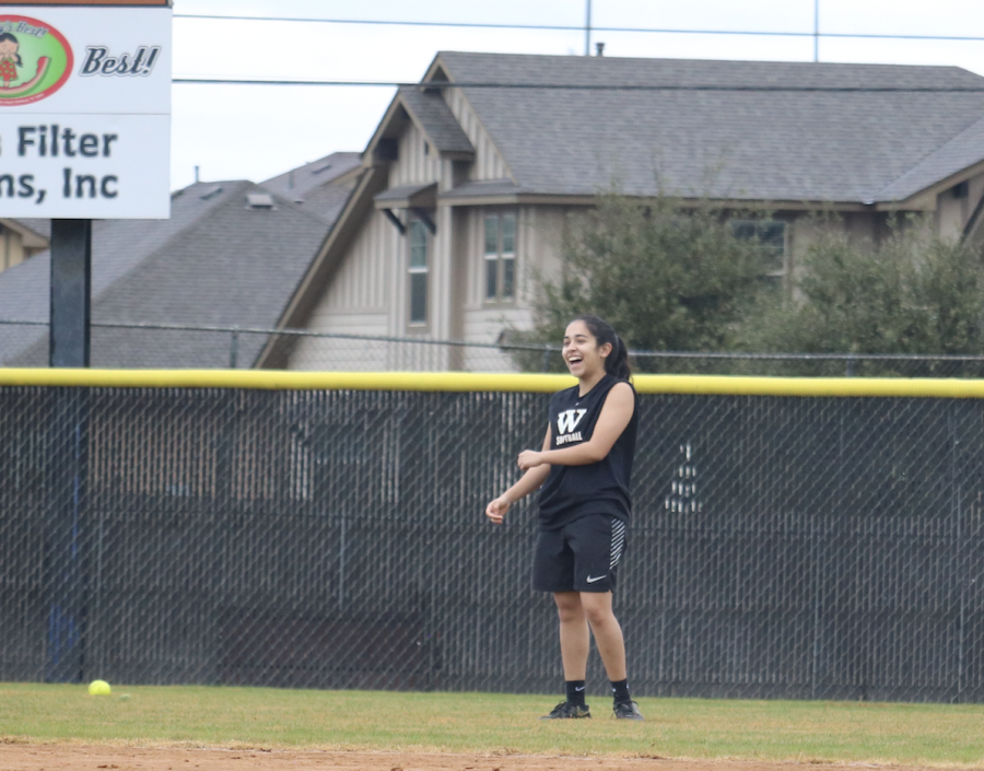 Haily Lozano 19 smiles and laughs in the outfield.