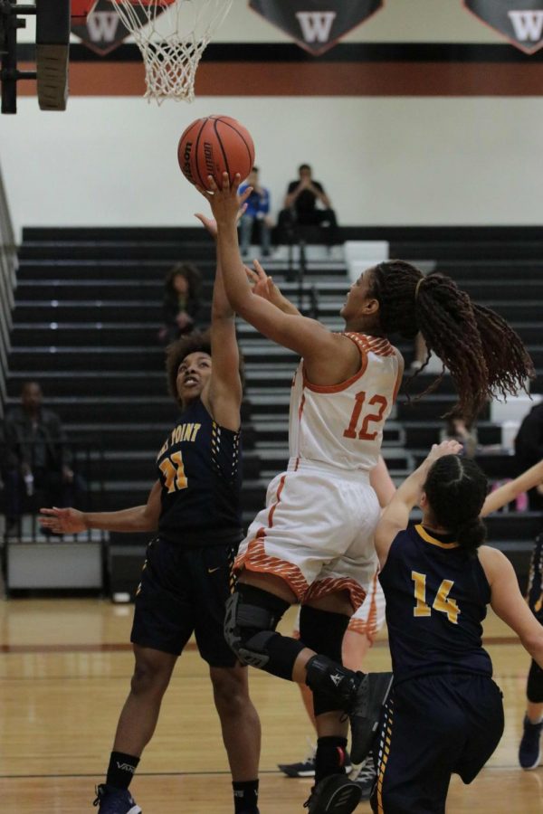 Allyah Beaty 18 shoots a layup with pressure from the Tiger defense.