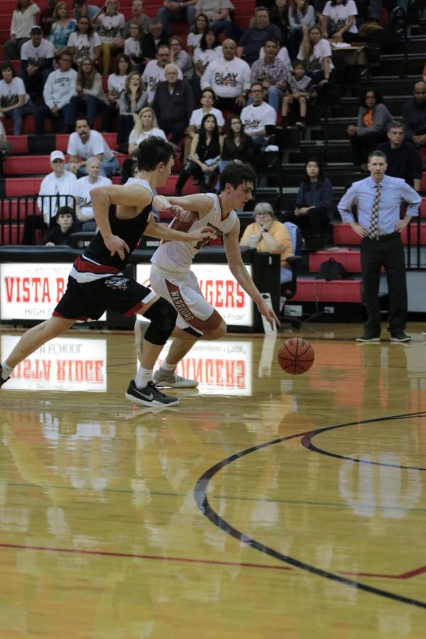 Daniel Victor 18 dribbles the ball down the court.