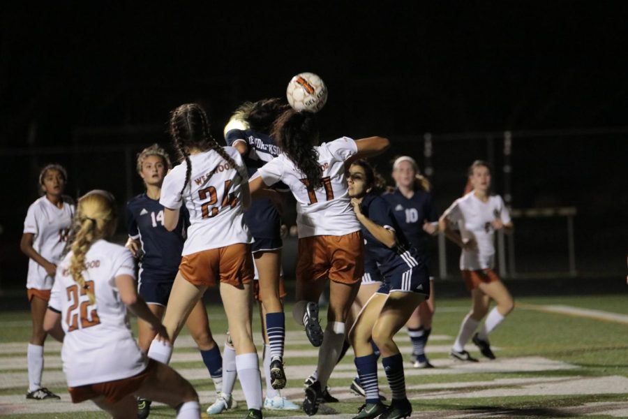 The Lady Warriors jump in attempt to head the ball towards their goal.