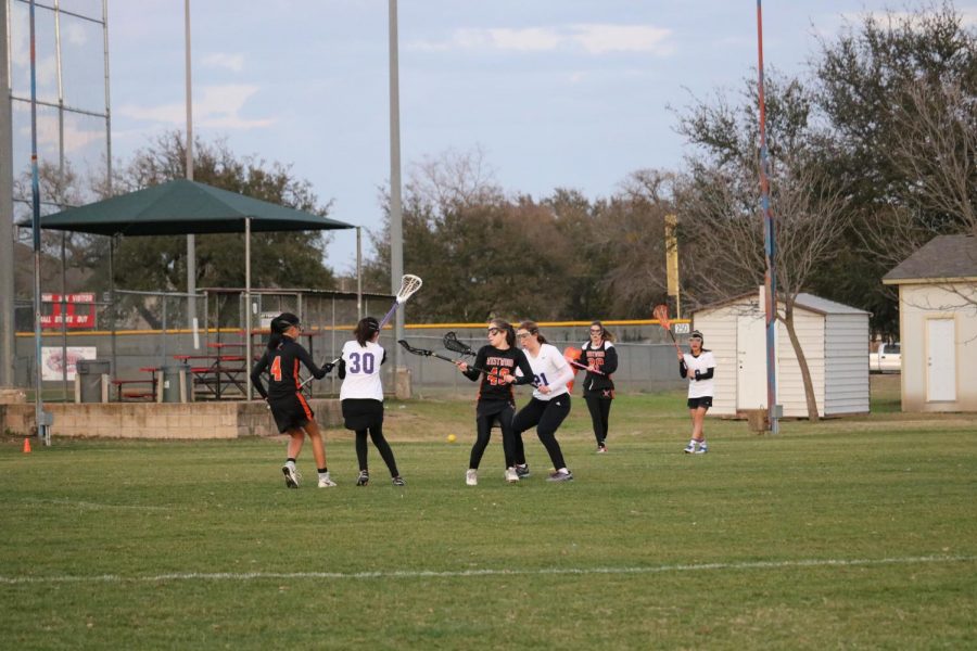 The Westwood Girls Lacrosse team tries to get the ball away from LBJ.