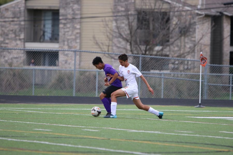 Noah Lugani 21 fights to gain possession of the ball from a Cedar Ridge player.