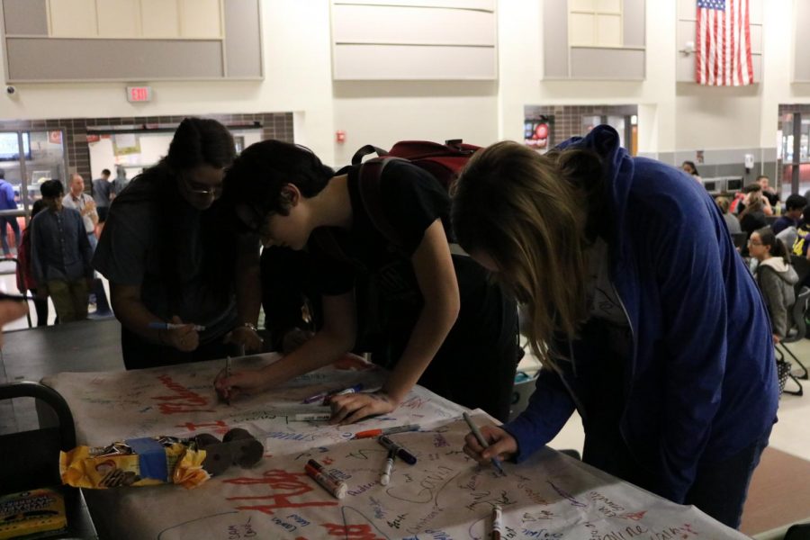 Westwood students sign a banner for Melanoma Awareness week.
