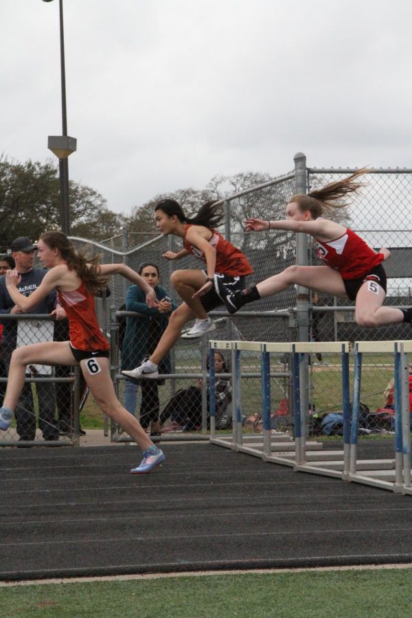 Shannon Lei 21 and Dana Mewhinney 21 run the 100-meter hurdles.