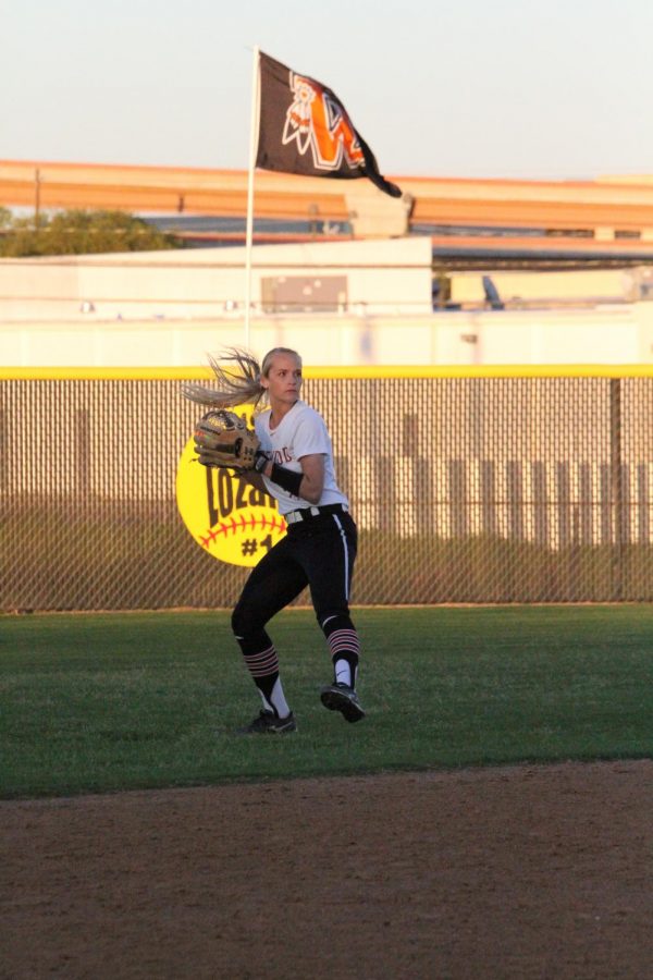 Alyssa Popelka 19 throws the ball to the pitcher.