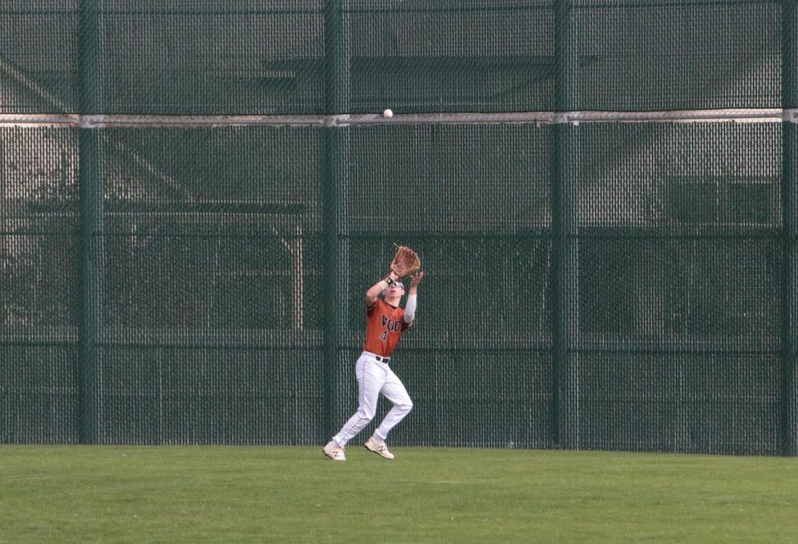 Chad Dixon 18 catches a ball in the outfield to get a player out.