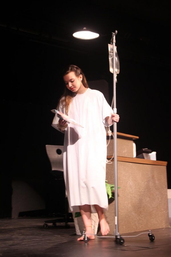 Isabella Barber 19 walks across stage in a hospital gown.
