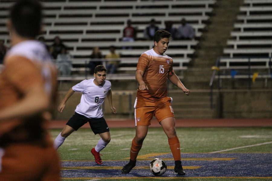 Evan Moreno 18 gets ready to kick the ball to another Warrior player.