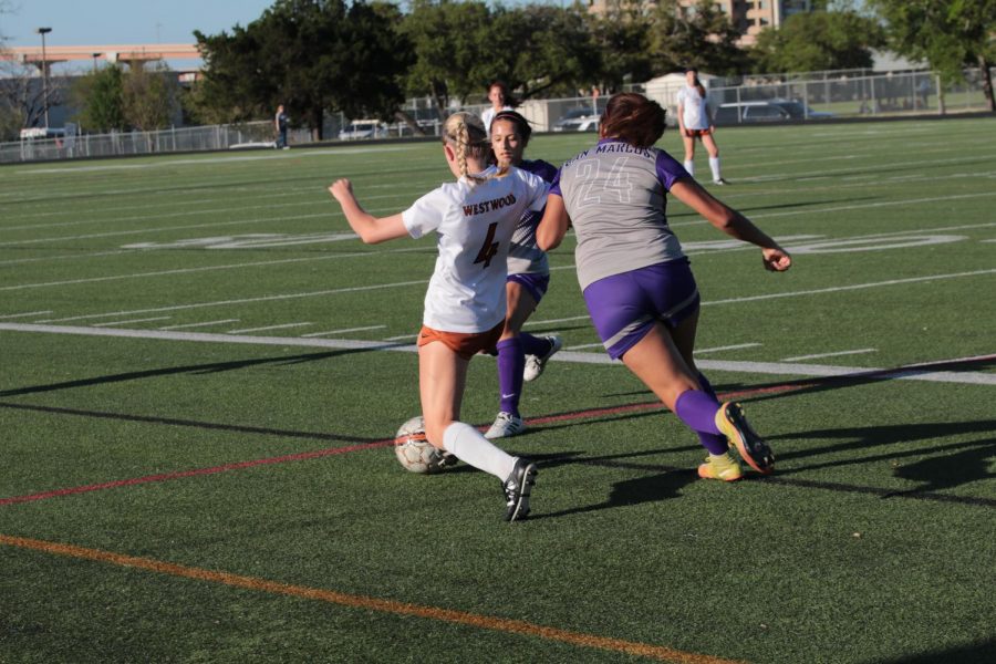 Olivia Graves 18 protects the ball as defenders attack for possession.