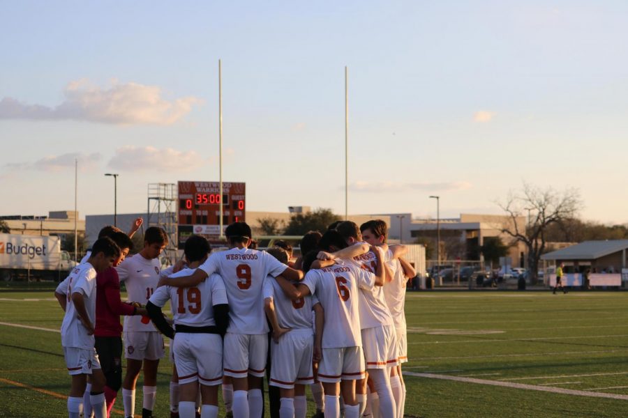 The team huddles before the game during the golden hour.
