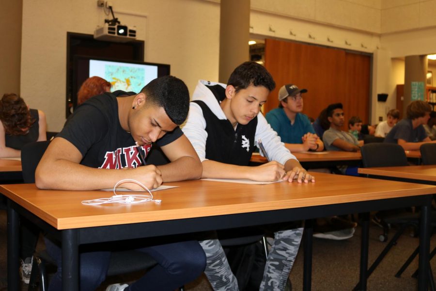 Luis A Rodriguez 18 and Cesar Frias 20 write down story ideas they have.