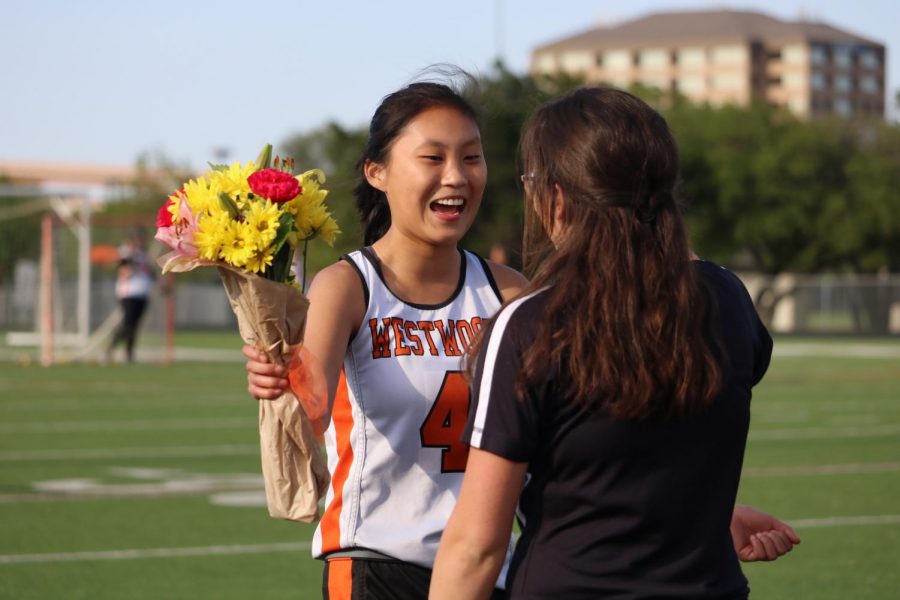 Olivia Green 18 accepts flowers from Coach Kathryn Hoyte