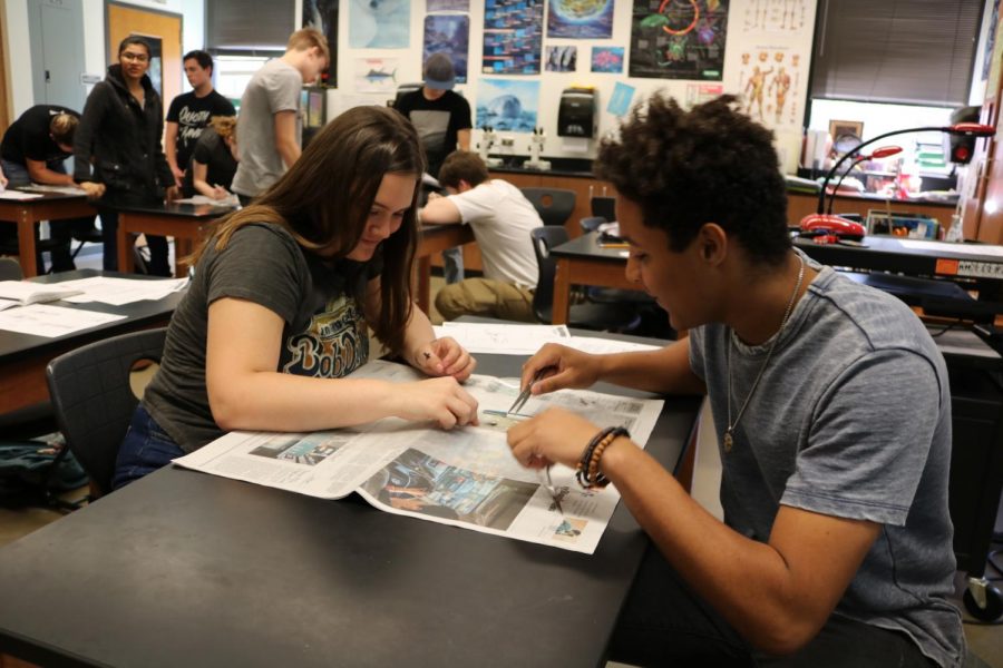 Katelyn Wignall 20 and Zach Lofton 18 disect a squid during aquatic science.
