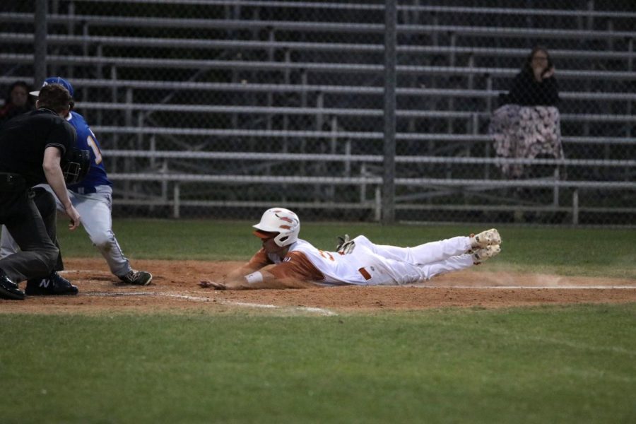 Cody Crider 20 slides to get on home plate before the ump calls him out.