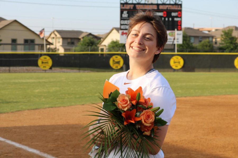 Alex Reece 18 poses with her flowers after being honored on the field.