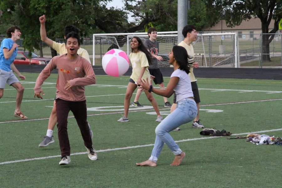 Students play volleyball with a beach ball.