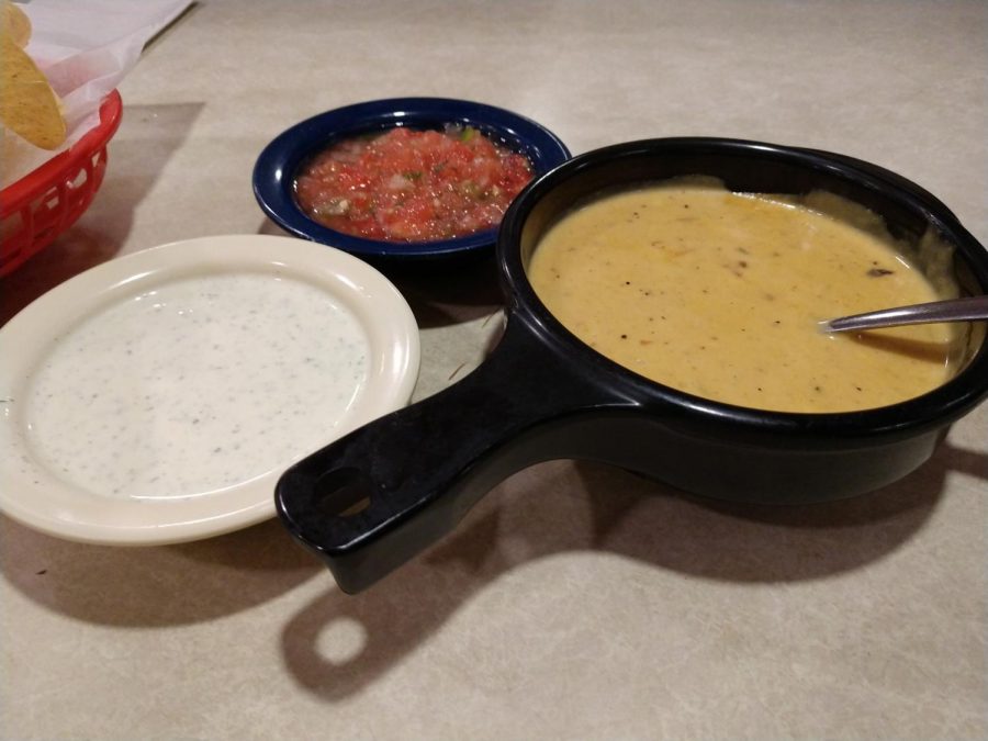A bowl of queso, jalapeno, and salsa