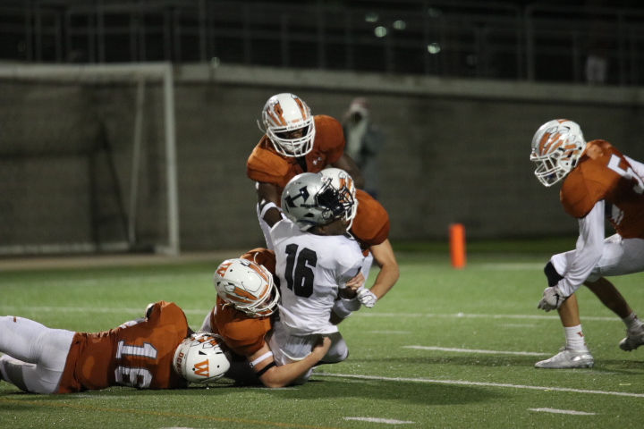 Multiple Westwood players tackle a Hendrickson player.