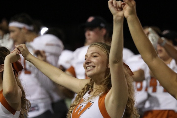 Lily Baizer 20 raises her arms during the alma mater at the end of the game. 